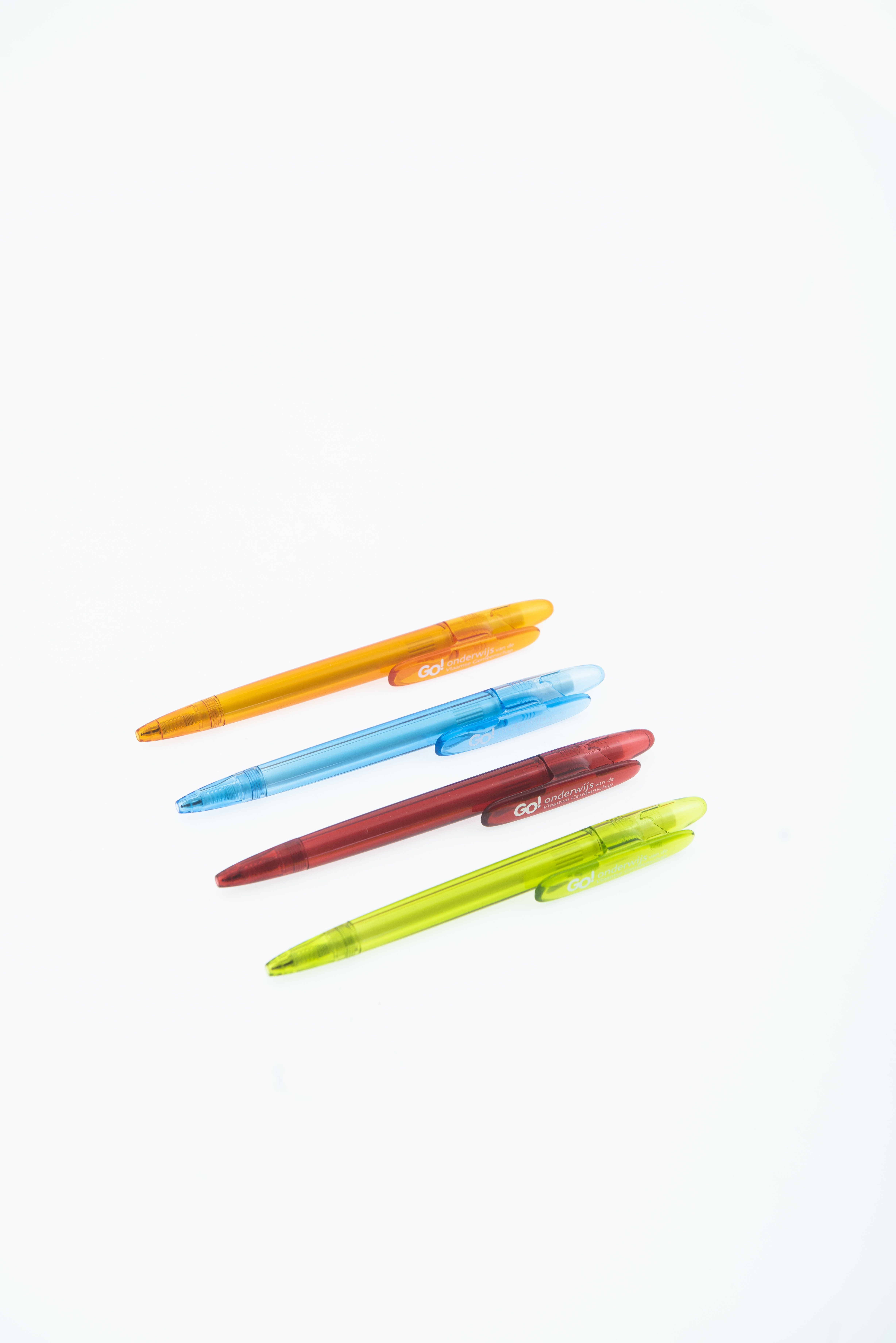 Vier Kleurrijke GO! Balpennen Op Een Rij Tegen Een Witte Achtergrond